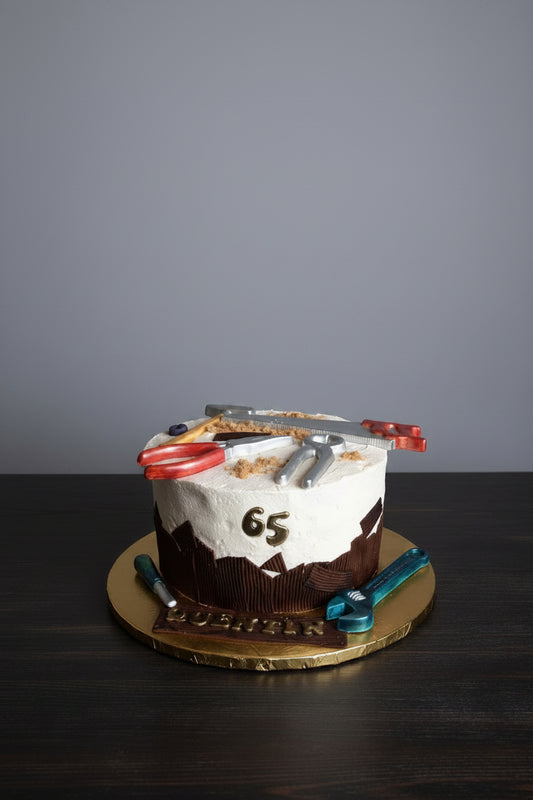 Cake with tools and number 65 on a wooden stand against a gray background